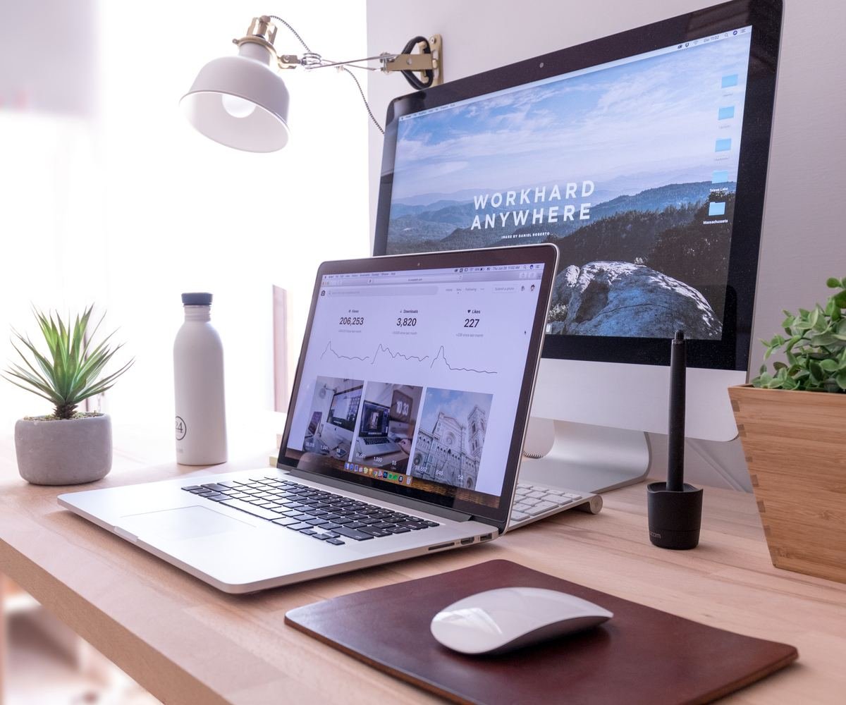 Bureau avec un ordinateur portable et un grand écran affichant des sites web